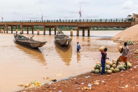 Homens preparam carregamento de melancias à beira de rio no Níger