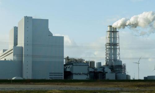imagem mostra uma usina emitindo gases poluentes