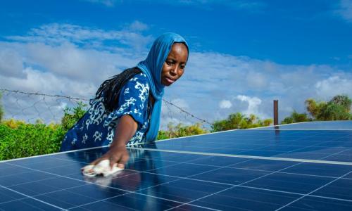 Mulher limpa um painel solar na Mauritânia