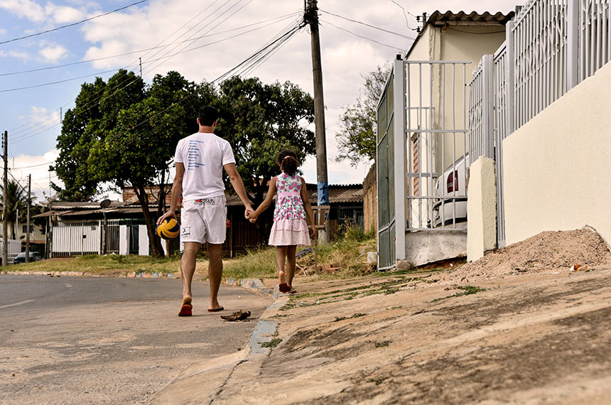 <p>foto mostra pai e filha em calçada inclinada, ruim</p>