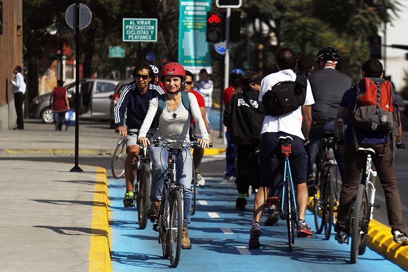 <p>Ciclistas pedalando em ciclovia em Santiago</p>