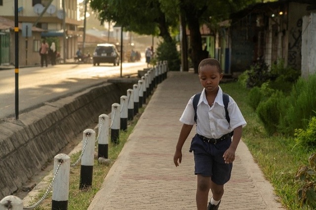 <p>uma criança em Dar es Salaam caminha até a escola</p>