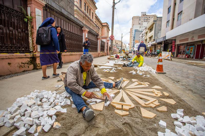 <p>foto de homem instalando piso da calçada</p>