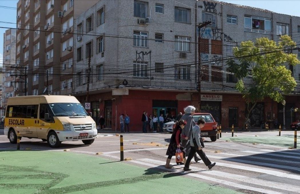 <p>idosa e crianças atravessam rua</p>