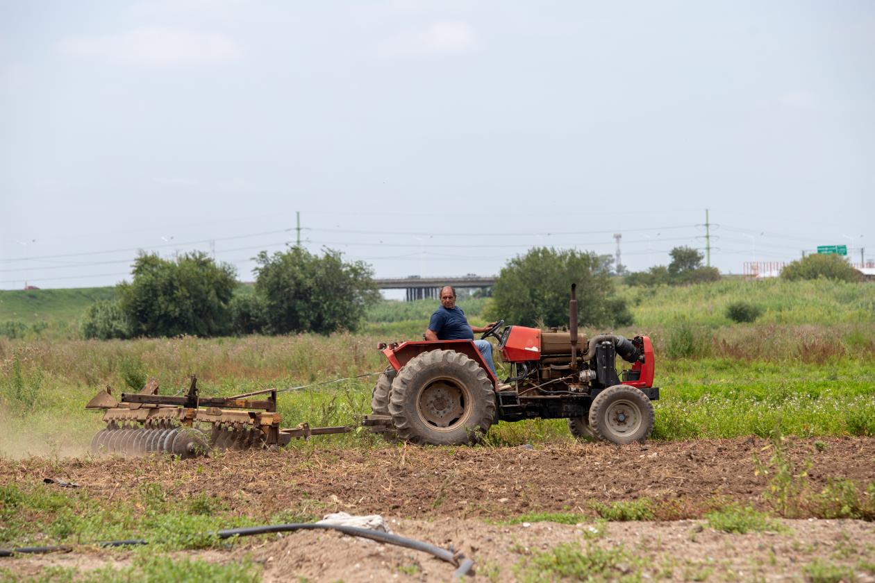 <p>foto mostra agricultor usando trator para arar a terra</p>