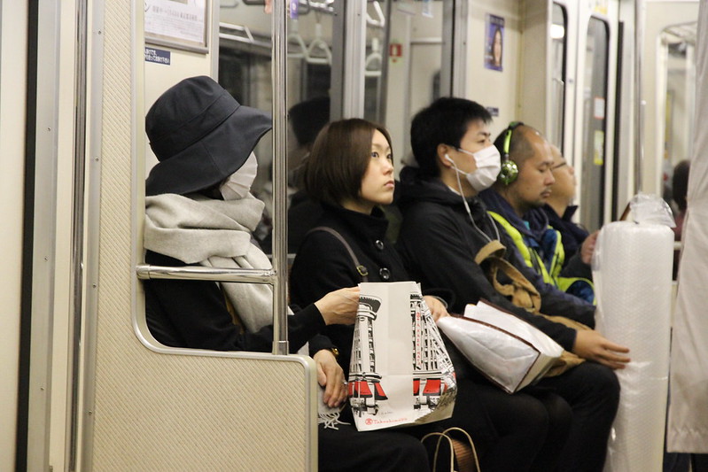 japoneses de máscara no metrô
