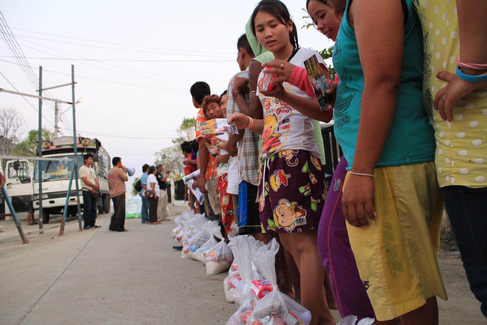 <p>fila de trabalhadores tailandeses e imigrantes do Laos e Mianmar afetados por enchente em 2011</p>